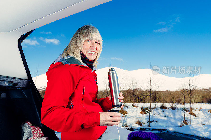 老妇人准备在苏格兰高地雪地里徒步旅行