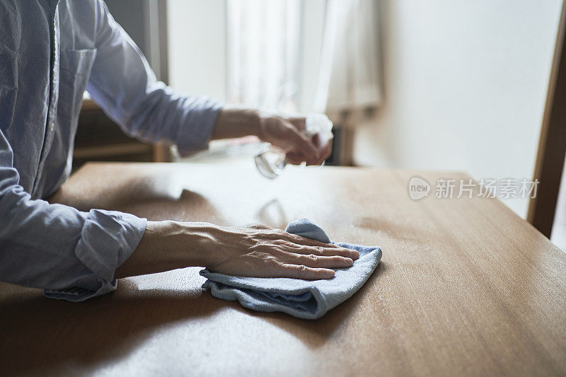 男人在家里用酒精消毒桌子