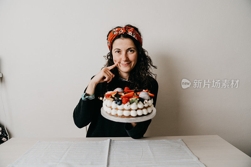 一个女人正在家里用奶油馅饼庆祝她的生日