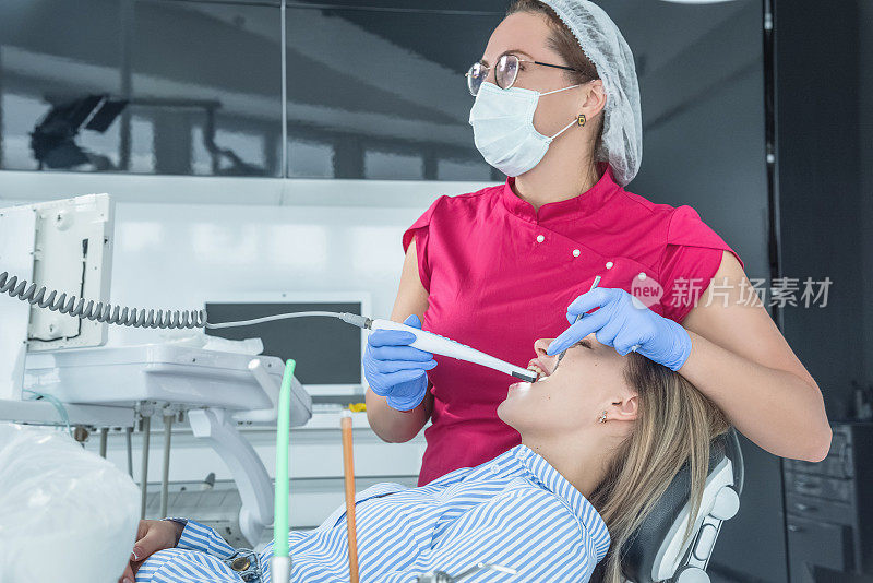 牙医在牙科诊所的接待处检查病人。医疗设施中的保健和治疗概念