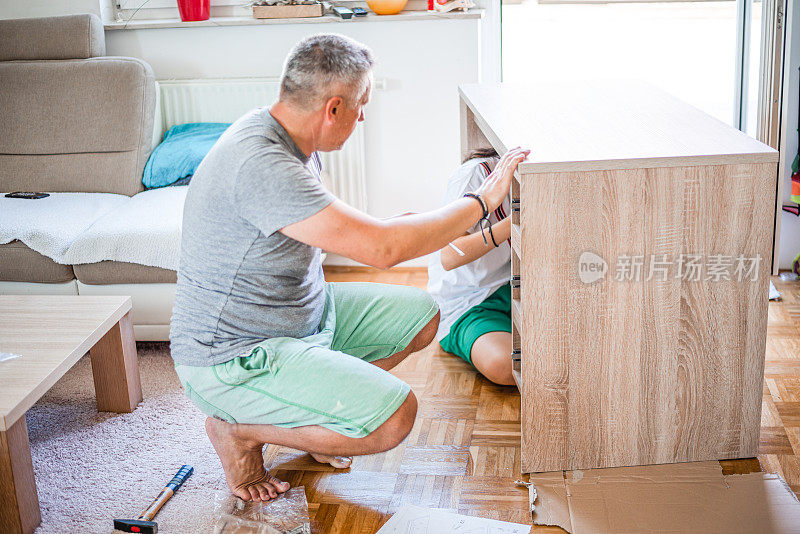 成年男子和年轻女子在家里组装新家具