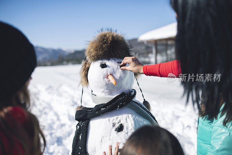 妈妈和孩子们在堆雪人