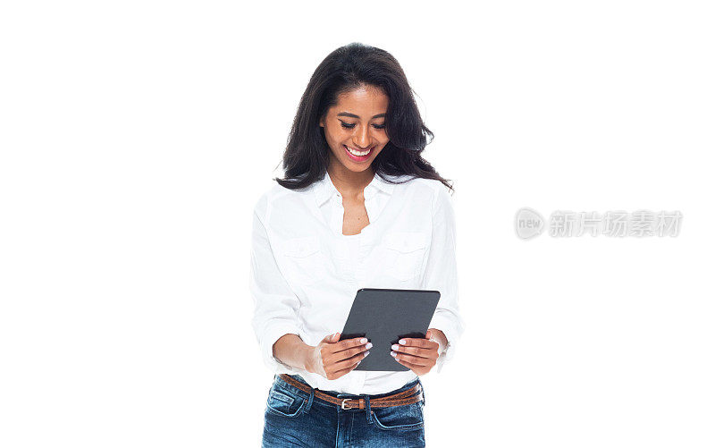 拉丁美洲和西班牙裔的年轻女性穿着衬衫站在白色背景前使用数字平板电脑