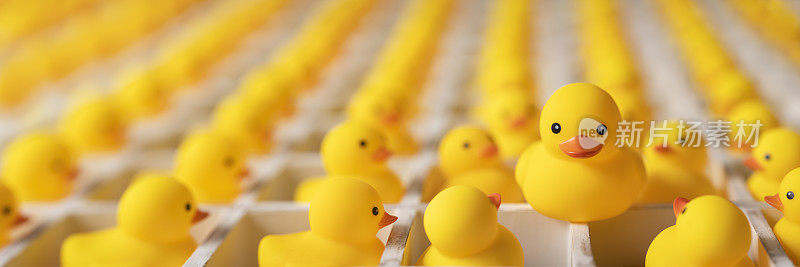 许多黄色的橡皮鸭在白色的木制鸽子洞盒子看着一个更大的鸭子是免费的在盒子外面。概念形象涉及思维的创新、自由、脱颖而出、个性、成功等。