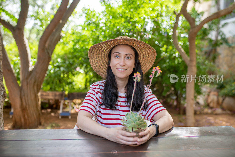 女人捧着开花的肉质植物