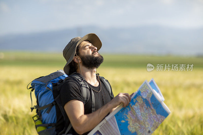 夏天徒步旅行的人在大自然中，旅行者在田野的小径上行走。