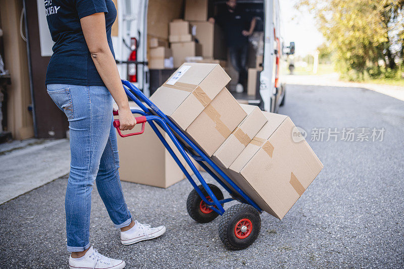 特写的年轻女性零工递送司机与手卡车