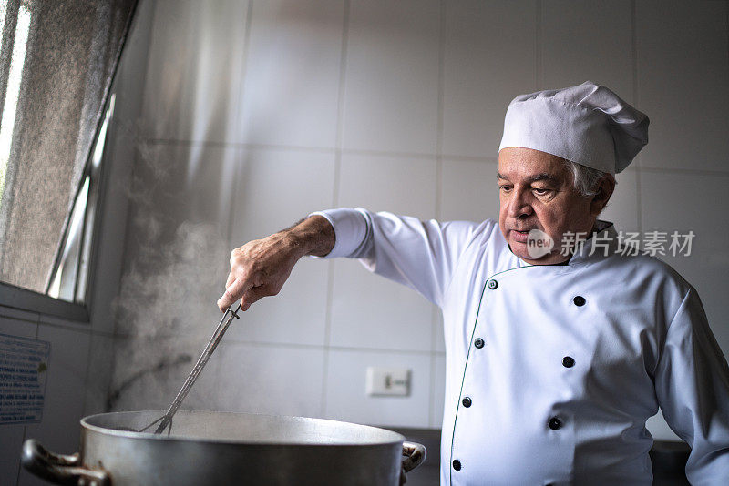 高级厨师在一个工业厨房里准备油炸食品