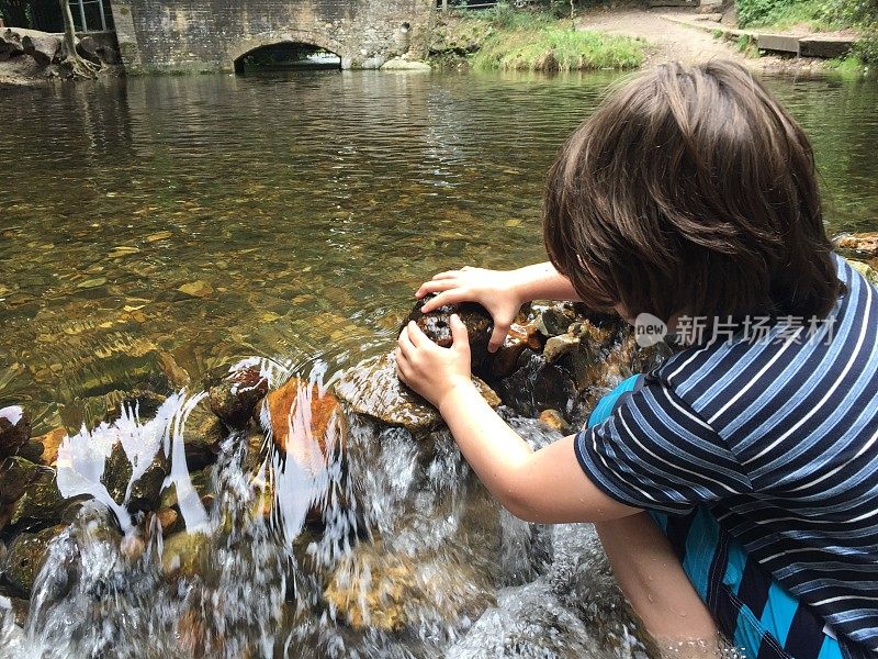 男孩在河里玩耍