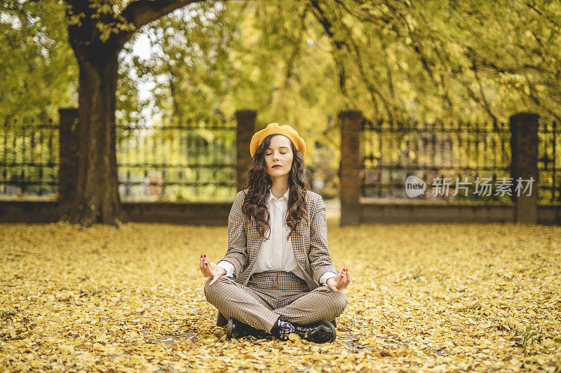 女人练习瑜伽，享受秋天的一天