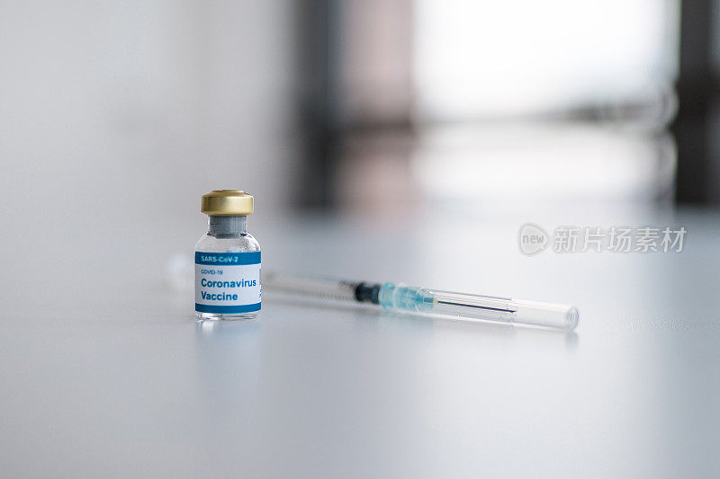 医生办公室桌上的COVID-19疫苗和注射笔