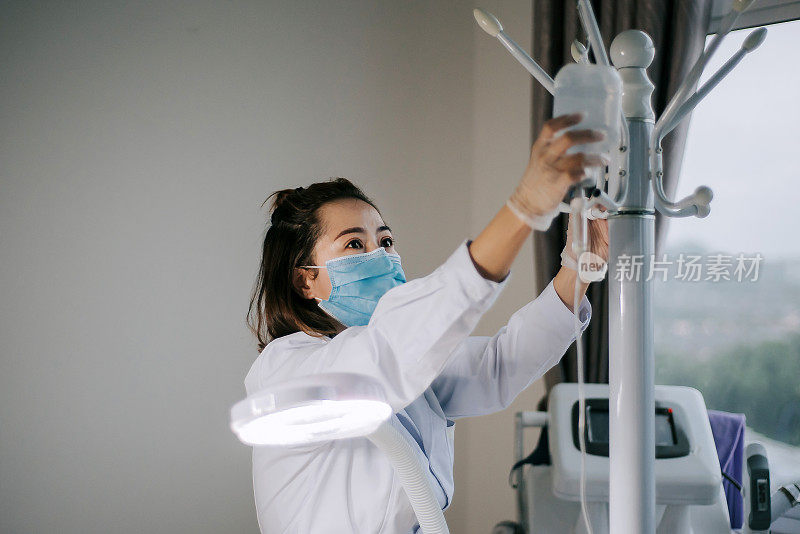 亚裔华裔女护士在临床准备和调整生理盐水注射