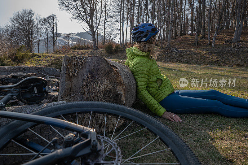 女山地摩托车手靠在树干上休息