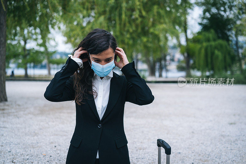 年轻女商人在户外脱下防护面罩的肖像