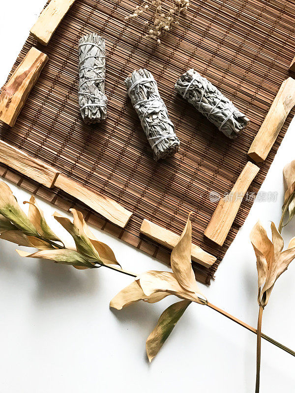 一个简单和美丽的背景，在竹子基质上的香精和香。特写微距拍摄的白鼠尾草和帕洛桑，有点模糊和模糊的焦点