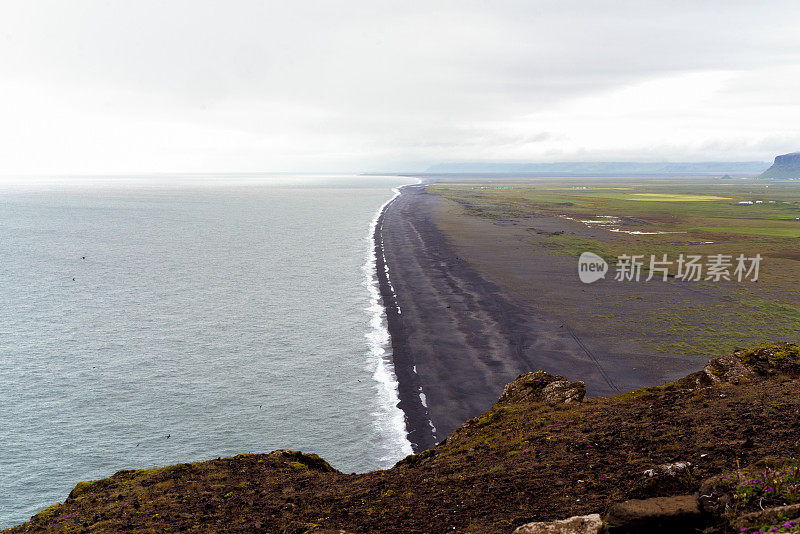 在冰岛南部多云多雨的天气里，从雷尼斯菲加拉黑沙滩附近的灯塔上观看