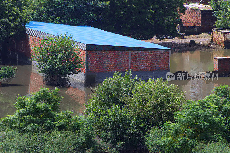 淹水的耕地，淹水的农业建筑，农田被分割成矩形块的农业区，印度季风季节