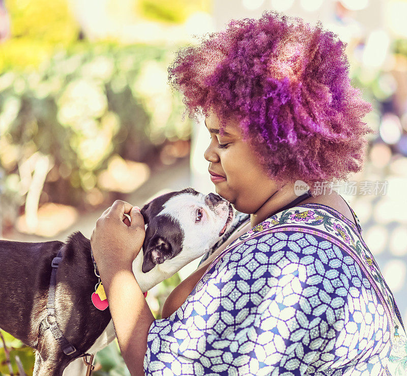 非洲裔美国妇女在户外与可爱的宠物狗波士顿小猎犬在一起