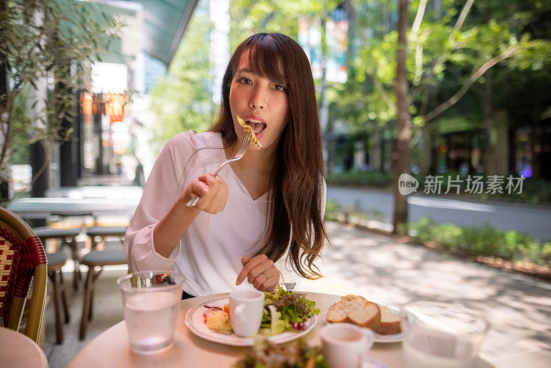 一名日本女子在露台咖啡馆吃午餐