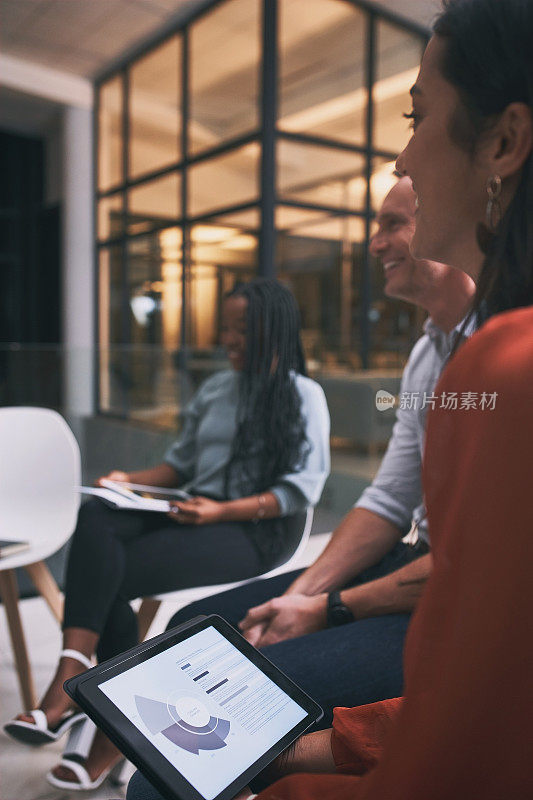 一名年轻女子在团队会议上使用平板电脑