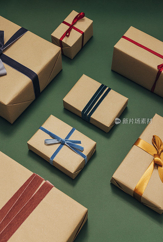 细心包装和装饰圣诞礼物在绿色表面