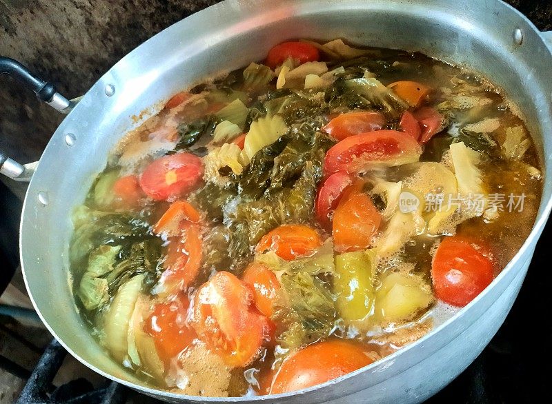 煮腌莴苣和番茄汤与猪肉裂口在炉灶食品准备。
