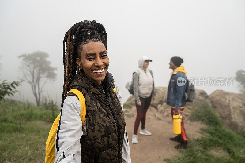 一个年轻女人的肖像在一个trail和朋友的背景