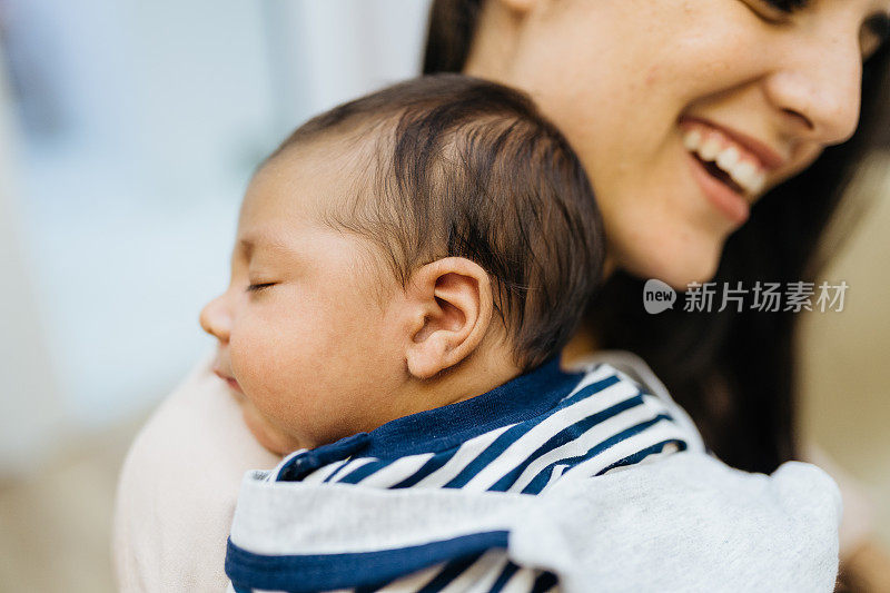 微笑的母亲肩上抱着新生的婴儿