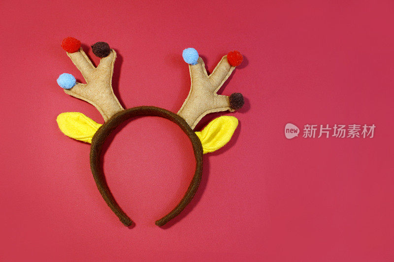 彩色驯鹿鹿角头带。圣诞快乐。在红色背景中