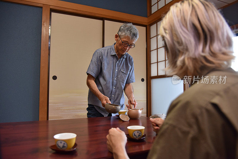 日本茶农为游客提供茶叶-库存形象