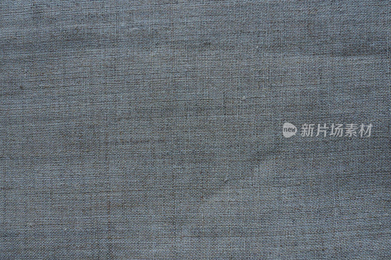 织物纹理背景。带编织的灰色织物。面料自然略带褶皱的外观。统一复制空间背景。棉、帆布或羊毛薄织物均匀铺在表面。
