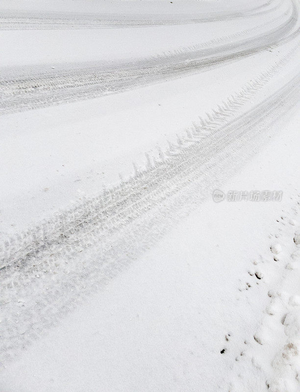 汽车轮胎印在路上刚落下的软雪上。