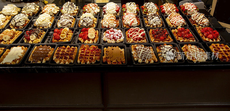在比利时布鲁塞尔出售的传统甜华夫饼甜点和调味品