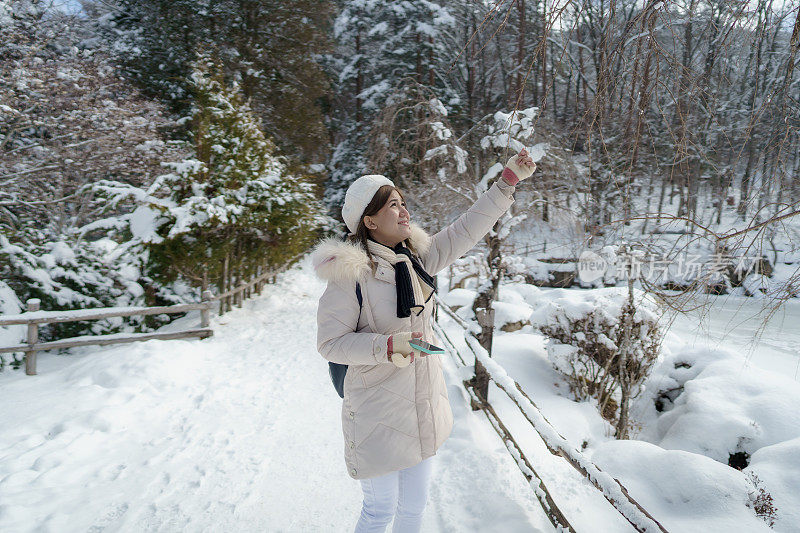 美丽的女子游客享受他们的日本之旅在雪的冬天
