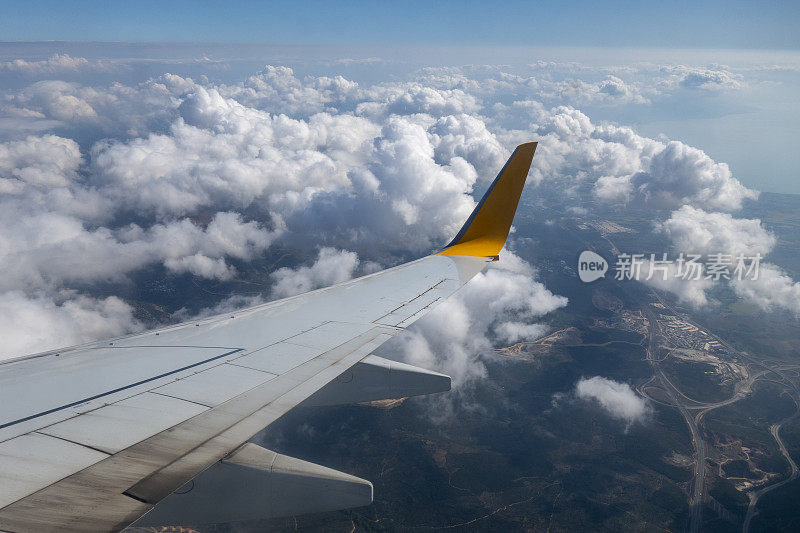 飞机的机翼在天空的云层上飞行