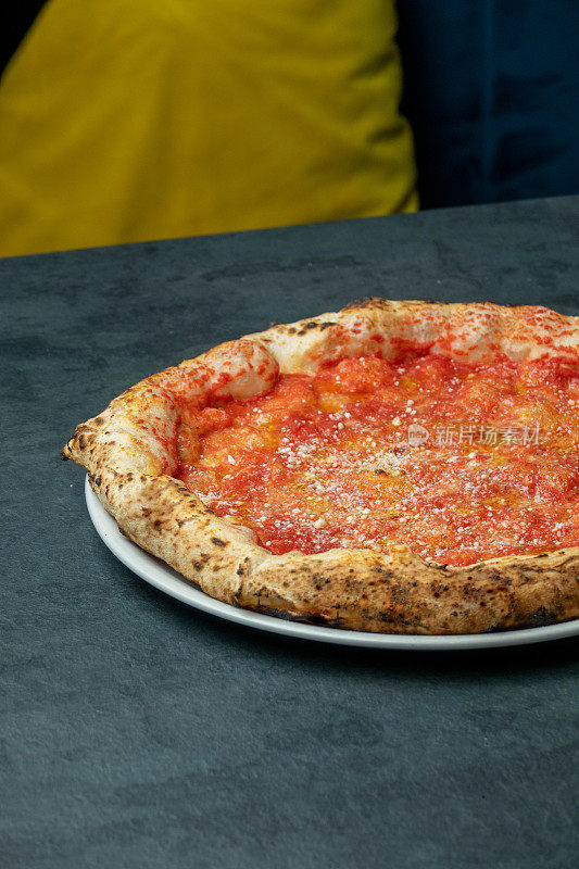 那不勒斯披萨配番茄和磨碎的奶酪，吃披萨店的桌子