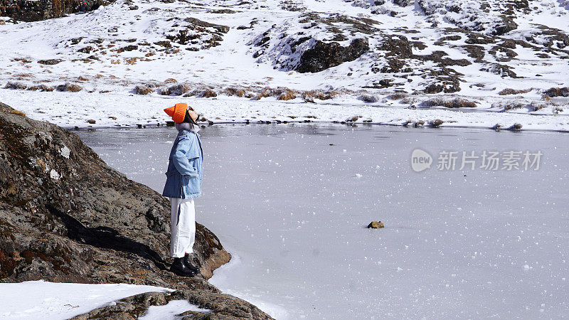 一个女人在寒冷的天气里穿行于白雪覆盖的山林之中