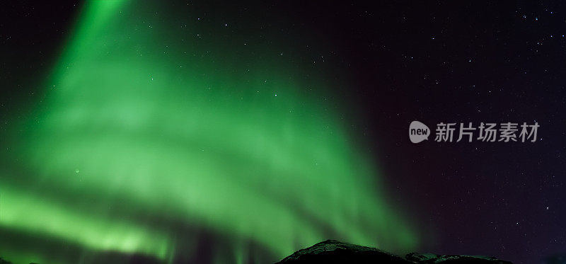 南极光或北极光或绿色北极光在山上的天空。北极光的夜空。夜晚冬季景观与南光极光对真正的自然黑色背景。