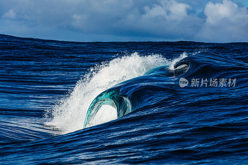 在开阔的海洋中，蓝色的波浪汹涌澎湃，掠过浅海礁石