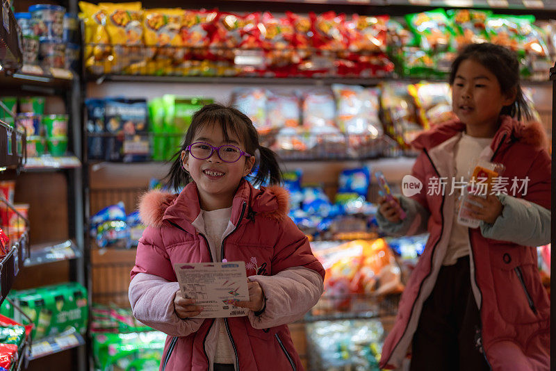 两姐妹在店里愉快地挑选零食