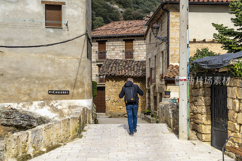 一位游客走过一个中世纪的小村庄——西班牙
