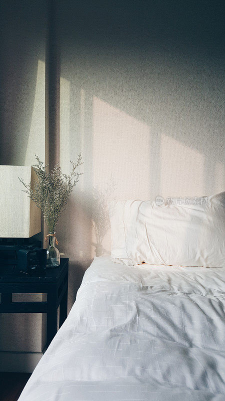 温暖的晨光照在毛茸茸的白色床上