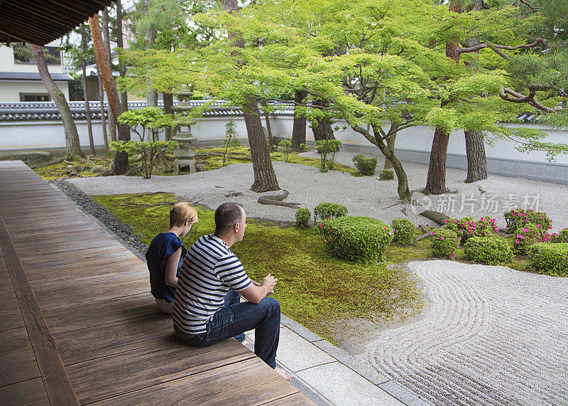 一对游客在日本寺庙的花园中放松