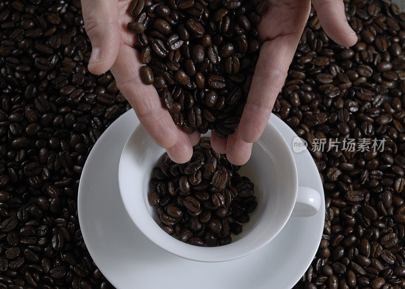 双手将咖啡豆倒入咖啡杯中