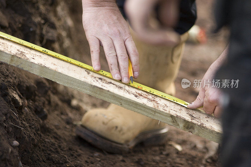 建筑商在建筑工地上标记木材