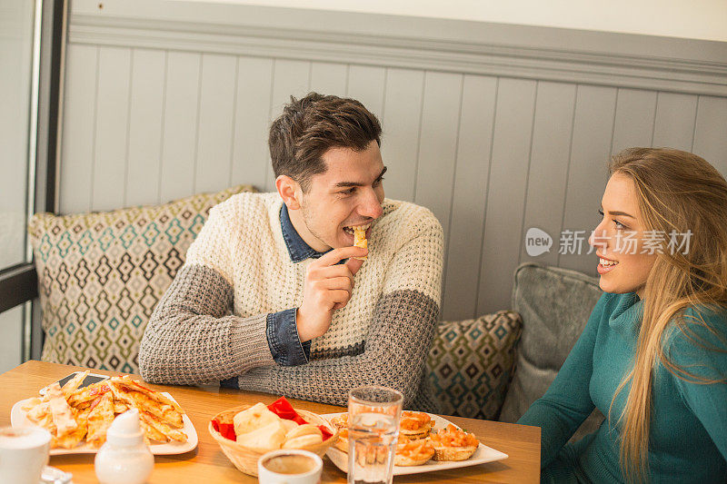 年轻夫妇在咖啡馆吃早餐