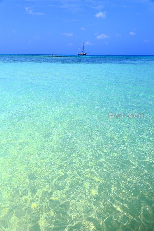帆船和加勒比海田园诗般的海滩下的蓝天-阿鲁巴