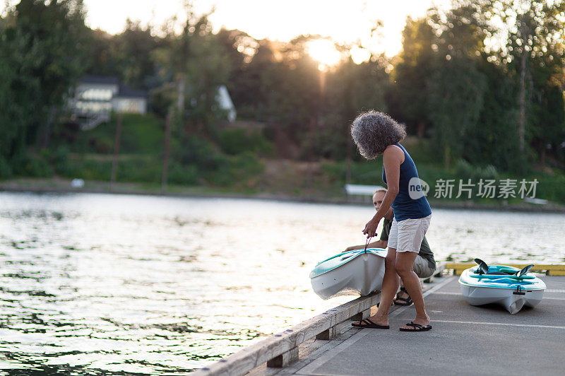 一对成熟的老夫妇准备在夏天一起划皮划艇