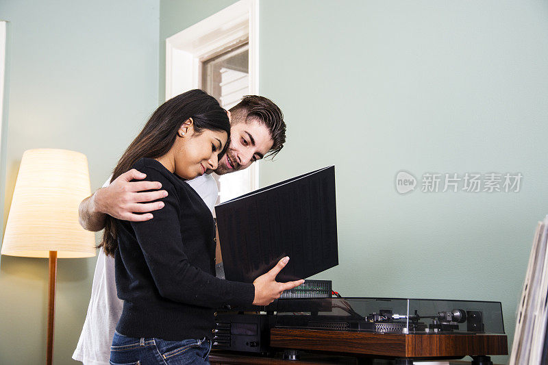 一对夫妇在家里看黑胶唱片。
