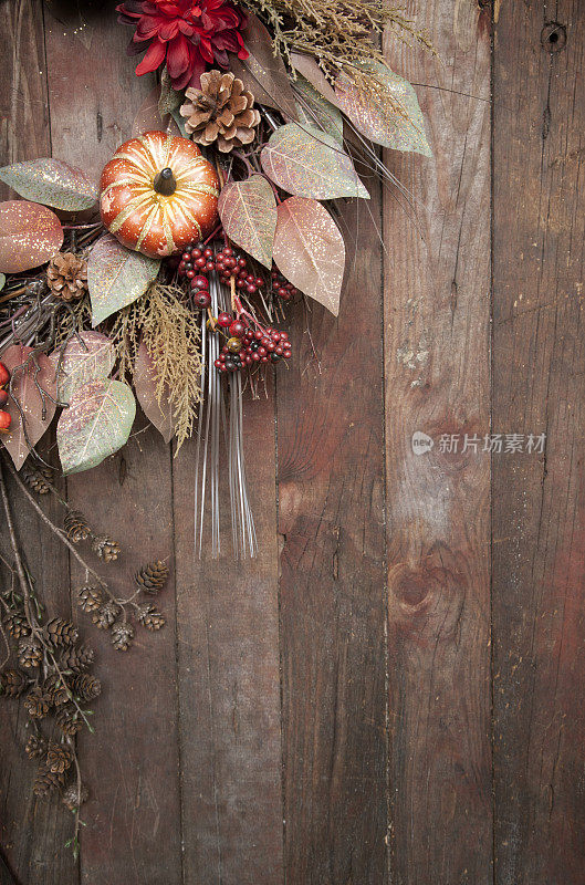 节日的秋花环放在破旧的乡村木门上